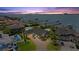 Stunning aerial view of waterfront home with swimming pool, lush landscaping, and boat docks at sunset at 2924 River Point Dr, Daytona Beach, FL 32118
