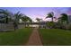 Lush backyard with well-maintained lawn, walkway, and palm trees leading to the home at 2924 River Point Dr, Daytona Beach, FL 32118