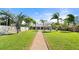 Lush backyard with well-maintained lawn, walkway, and palm trees leading to the home at 2924 River Point Dr, Daytona Beach, FL 32118