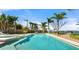 Backyard view showcases a large, sparkling pool surrounded by lush landscaping and towering palm trees at 2924 River Point Dr, Daytona Beach, FL 32118
