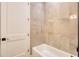 Bathroom features a white tub with gray tile surround and a white door at 32 Ocean Breeze Cir, Ormond Beach, FL 32176