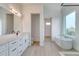 Bright bathroom featuring double sinks, free-standing tub, and modern fixtures at 32 Ocean Breeze Cir, Ormond Beach, FL 32176