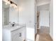 Bathroom featuring a white vanity, neutral walls, and black hardware near stairs at 32 Ocean Breeze Cir, Ormond Beach, FL 32176