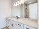 Modern bathroom with white cabinets, marble countertop, and a large mirror reflecting a tiled shower at 32 Ocean Breeze Cir, Ormond Beach, FL 32176
