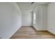 Minimalist bedroom featuring light wood floors, white walls, and a single window at 32 Ocean Breeze Cir, Ormond Beach, FL 32176
