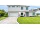Contemporary two-story home with an attached garage, manicured lawn, modern windows, and a stylish, welcoming entrance at 32 Ocean Breeze Cir, Ormond Beach, FL 32176