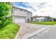 Two-story home boasts neutral colors, a brick driveway, and attached two-car garage at 32 Ocean Breeze Cir, Ormond Beach, FL 32176
