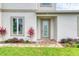 Close up of the modern front entrance with a glass door and landscaping at 32 Ocean Breeze Cir, Ormond Beach, FL 32176