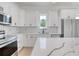 Bright kitchen features white cabinets, stainless steel appliances, and an island at 32 Ocean Breeze Cir, Ormond Beach, FL 32176