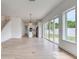 Bright living room with backyard access and wood-look floors leading to the kitchen at 32 Ocean Breeze Cir, Ormond Beach, FL 32176