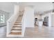 Living room shows staircase and view into open-concept kitchen with stainless appliances at 32 Ocean Breeze Cir, Ormond Beach, FL 32176