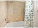 Clean and modern bathroom with tiled walls, a white bathtub, and a decorative shower curtain at 3205 Bailey Ann Dr, Ormond Beach, FL 32174