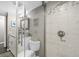 Well-lit bathroom with shower featuring decorative tiles, glass door and toilet at 3370 Ocean Shore Blvd # 206B, Ormond Beach, FL 32176