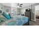 Bedroom featuring wood-look flooring, coastal decor, ceiling fan, and plantation shutters at 3370 Ocean Shore Blvd # 206B, Ormond Beach, FL 32176