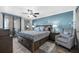 Comfortable main bedroom features a coastal blue accent wall, ceiling fan, and balcony access at 3370 Ocean Shore Blvd # 206B, Ormond Beach, FL 32176