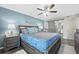 Cozy bedroom featuring a comfortable queen bed, accent wall, ensuite bathroom, and ceiling fan at 3370 Ocean Shore Blvd # 206B, Ormond Beach, FL 32176