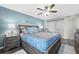Cozy bedroom featuring a comfortable queen bed, accent wall, and ceiling fan at 3370 Ocean Shore Blvd # 206B, Ormond Beach, FL 32176