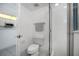 Small bright white bathroom with glass enclosed shower with a small view into the kitchen at 4631 S Atlantic Ave # 8706, Ponce Inlet, FL 32127