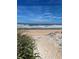 Beautiful beach with blue skies, white sand, and green dune grass for a relaxing coastal living experience at 48 Rosewood Ave, Ormond Beach, FL 32174