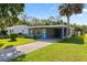 Well-kept single-story home featuring a carport, landscaped front yard, and welcoming curb appeal at 48 Rosewood Ave, Ormond Beach, FL 32174
