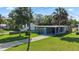 Charming home featuring a carport, well-manicured lawn, and blue exterior accents at 48 Rosewood Ave, Ormond Beach, FL 32174