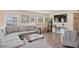 Cozy living room featuring a gray sectional sofa, wood-look floors, and a wall-mounted TV at 48 Rosewood Ave, Ormond Beach, FL 32174