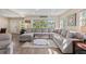 Spacious living room with a large sectional sofa, bright windows, and stylish decor at 48 Rosewood Ave, Ormond Beach, FL 32174