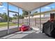 Screened-in back patio with an outdoor grill and space for seating at 48 Rosewood Ave, Ormond Beach, FL 32174