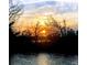 Picturesque sunset over the water with silhouetted trees creating a peaceful and scenic waterfront view at 48 Rosewood Ave, Ormond Beach, FL 32174