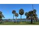 Scenic waterfront view featuring palm trees, benches, and a clear blue sky, ideal for relaxing and enjoying the scenery at 48 Rosewood Ave, Ormond Beach, FL 32174