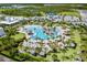 Aerial view of community pool and amenities with palm trees, tiki huts, and lush landscaping at 540 Good Life Way, Daytona Beach, FL 32124