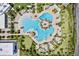Stunning overhead view of a resort-style pool area featuring multiple pools, lush landscaping, and tiki huts at 540 Good Life Way, Daytona Beach, FL 32124