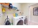 Well-organized laundry room featuring modern washer and dryer with ample shelving and storage space at 5431 Hutchinson St, Port Orange, FL 32128