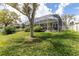 Spacious backyard featuring a screened enclosure and lush green grass at 6809 Plumpjack Ct, Port Orange, FL 32128