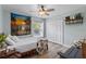 Cozy bedroom with light blue walls, ceiling fan, wooden floors, and a window providing ample natural light at 6809 Plumpjack Ct, Port Orange, FL 32128