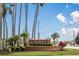 Waters Edge community entrance featuring a brick sign, lush landscaping, mature palm trees, and blue skies at 6809 Plumpjack Ct, Port Orange, FL 32128