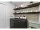 Efficient laundry room with modern washer and dryer, floating shelves, and stylish decor for a functional space at 6809 Plumpjack Ct, Port Orange, FL 32128