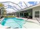 Backyard pool features screened enclosure, lounge chairs, tranquil water, and sunny sky above at 6809 Plumpjack Ct, Port Orange, FL 32128