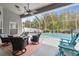 Inviting screened-in pool area with comfortable seating, a fire pit, and a serene water feature for relaxation at 6809 Plumpjack Ct, Port Orange, FL 32128