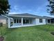 View of the back of the house, including a covered patio and green lawn at 1665 Lake Reserve Dr, Deland, FL 32724