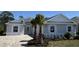 Charming single-story home showcasing a brick driveway, manicured lawn, and decorative palm trees at 1665 Lake Reserve Dr, Deland, FL 32724