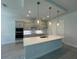 Bright and modern kitchen with an expansive island, pendant lights, and stainless steel appliances at 1665 Lake Reserve Dr, Deland, FL 32724