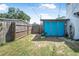 Backyard with fencing, grass and shed with bright blue doors, providing privacy at 1836 Biscayne Ave, South Daytona, FL 32119