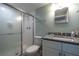 Bathroom featuring granite countertop, white vanity, and glass-enclosed shower at 1155 Ocean Shore Blvd # 702, Ormond Beach, FL 32176