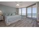 Bright bedroom featuring wood floors, ceiling fan, and balcony access with ocean view at 1155 Ocean Shore Blvd # 702, Ormond Beach, FL 32176