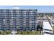 View of a condo building with manicured lawns and palms, right on a sandy beach at 1155 Ocean Shore Blvd # 702, Ormond Beach, FL 32176