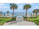 Inviting fenced pool area with ocean views, surrounded by lush lawns and swaying palm trees at 1155 Ocean Shore Blvd # 702, Ormond Beach, FL 32176