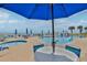 Relaxing poolside scene with lounge chairs and ocean views under the shade of a large blue umbrella at 1155 Ocean Shore Blvd # 702, Ormond Beach, FL 32176