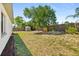 Backyard featuring a storage shed, wooden fence, and mature trees, offering a private outdoor space at 1197 Stillwood Ct, Port Orange, FL 32129