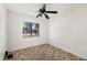 Bedroom with neutral walls, ceiling fan, and view to front yard at 1197 Stillwood Ct, Port Orange, FL 32129